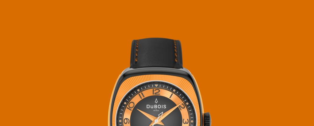 Bild der DBF010-02, einer Schweizer Luxusuhr von DuBois et fils, mit einem schwarzen Gehäuse und einer orangen Lünette. Die Uhr wird auf orangem Hintergrund dargestellt.