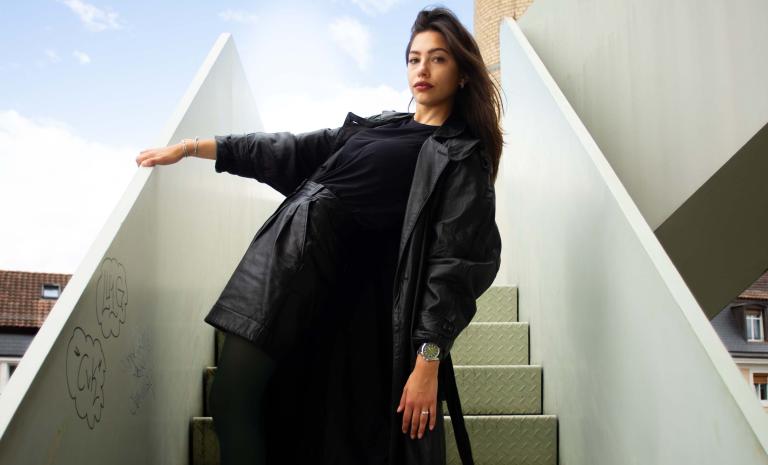 Frau trägt DuBois et fils DBF009 Fliegeruhr auf einer Treppe mit Himmel im Hintergrund